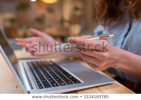 Foto stock: Young Female Hand With Pen Over Laptop Keypad During Remote Work