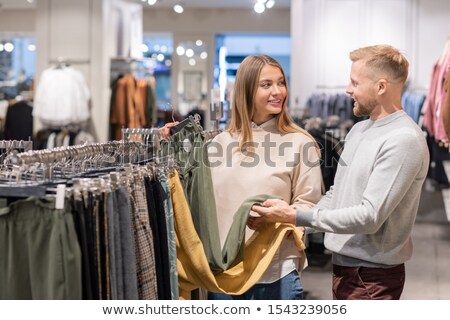 Foto stock: Pretty Girl And Young Man Choosing Between Yellow And Grey Pants