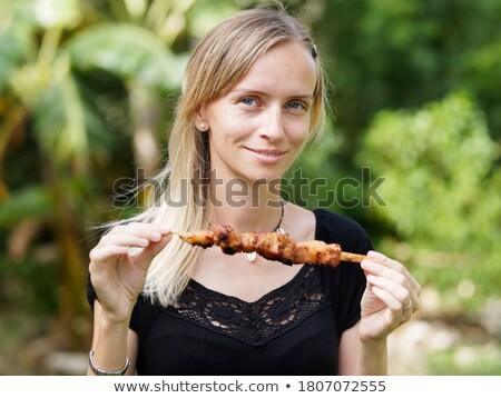 Foto d'archivio: Attractive Blond Woman Barbecuing Meat