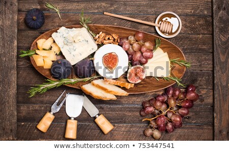Сток-фото: Assortment Of Cheese With Honey Nuts And Grape On A Rustic Cutting Board