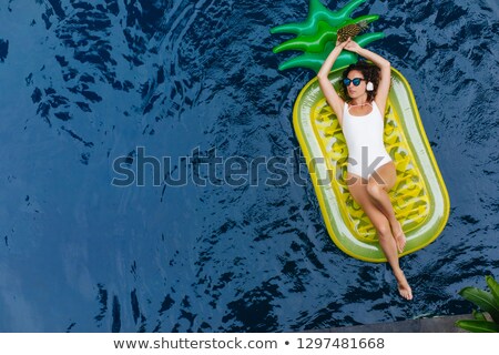 Stok fotoğraf: Cheerful Woman In Swimsuit Listening To Music And Laughing