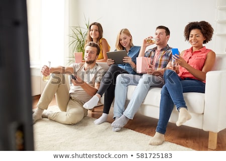 Foto stock: Friends With Smartphone Watching Tv At Home