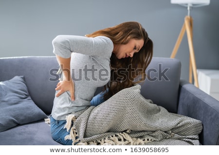 Zdjęcia stock: Woman Having Backache While Sitting On Sofa