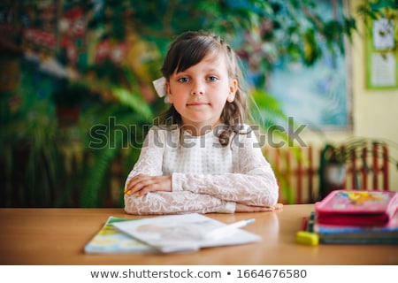 Foto stock: Portrait Of A Young Girl In School At The Desk