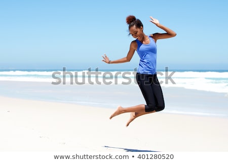 Stok fotoğraf: Cheerful Woman Jumping Laughing At Beach Portrait