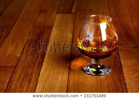Stok fotoğraf: One Glass Of Brandy On Antique Wooden Counter Top