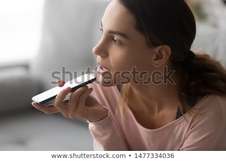 Foto stock: Young Pensive Woman Talking On The Phone And Looking Away At Home