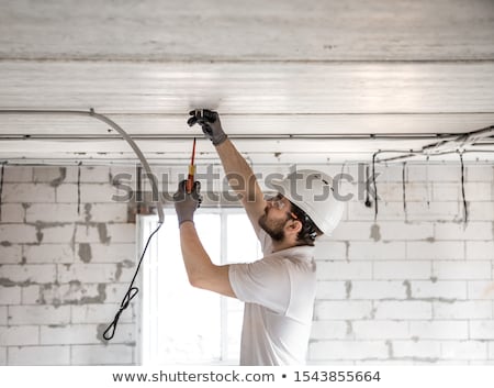 Stok fotoğraf: Electrician With Construction Tools And Cable