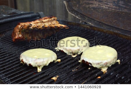 Stock fotó: Three Cheeseburgers And A Rack Of Lamb On A Grill