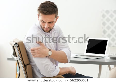 [[stock_photo]]: Man Sitting On Chair Suffering From Shoulder Pain