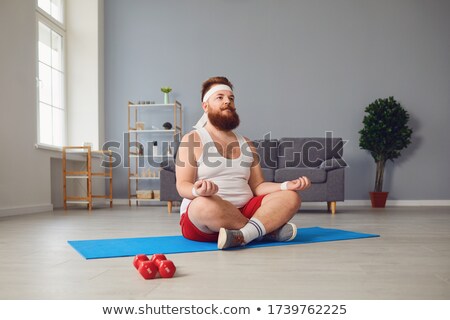 Stock photo: Man Meditating In Lotus Pose At Home