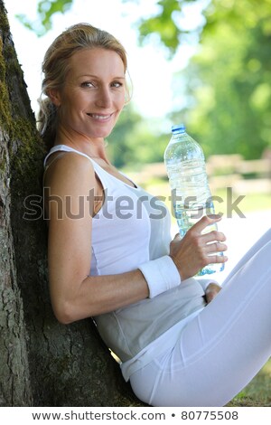 Stock fotó: Sporty Woman Taking A Break From A Country Run To Have A Drink