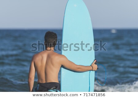 Surfer Carrying His Blue Surfboard From Behind Stockfoto © 2Design
