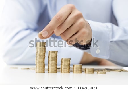 Stock photo: Male Hand Stacking Gold Coins Into Increasing Columns