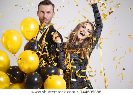 Stock fotó: Happy Couple With Party Blowers Having Fun