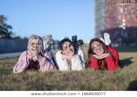 Portrait Of Three Young Woman Lying On A Green Lawn Stockfoto © 2Design