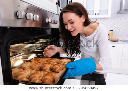 Foto d'archivio: Woman Checking Croissants With Toothpick