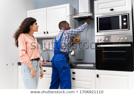 Foto stock: Technician Checking Extractor Filter With Digital Multimeter