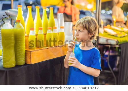 Stockfoto: Boy Drinking Sugar Cane Juice On The Asian Market