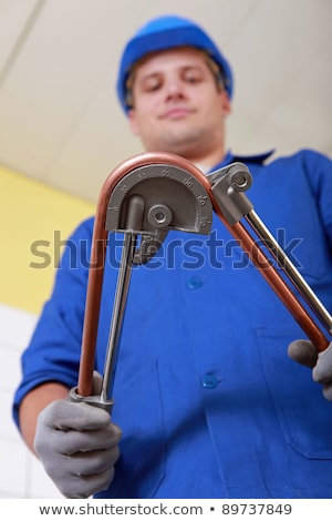 Foto stock: Tradesman Using A Tool To Bend A Copper Tool