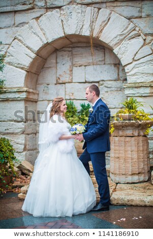 Stockfoto: Young Elegant Couple Looking At Each Other Near Column