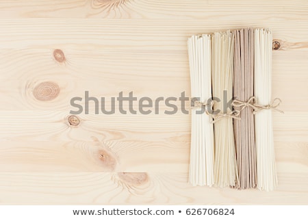 Zdjęcia stock: Bundles Of Raw Chinece Noodles On Soft Beige Wooden Board With Copy Space Top View