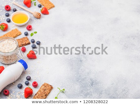 [[stock_photo]]: Organic Cereal Granola Bar With Berries With Honey Spoon And Jar Of Oats And Bottle Of Milk Drink On