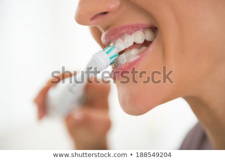 ストックフォト: Woman Brushing Teeth With Electric Toothbrush