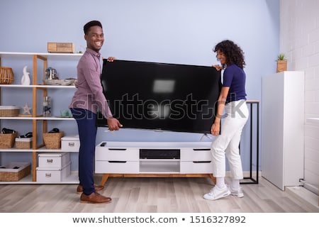 Сток-фото: Young Couple Lifting Television