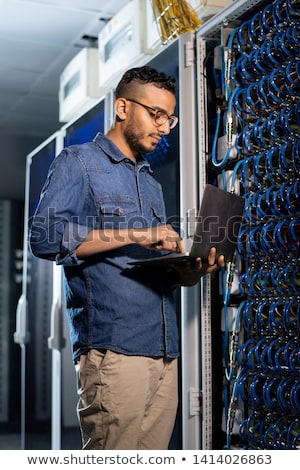 Imagine de stoc: Concentrated Network Engineer Examining Database Server