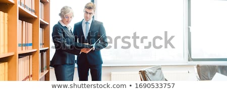 Stok fotoğraf: Senior And Junior Lawyer In Law Firm Discussing Strategy In A Case