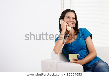 [[stock_photo]]: Happy Young Woman Lying On Sofa And Talking On Phone