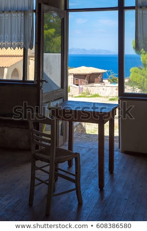 Сток-фото: Greece Romantic Composition Table And Chair Near The Window And Deep Blue Sea Behind