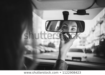 Сток-фото: Woman Applying Lipstick In A Car