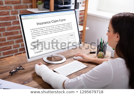 Stockfoto: Injured Woman Filling Work Injury Claim Form