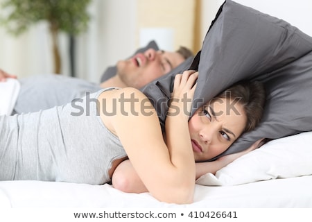 [[stock_photo]]: An Angry Man With Snoring Wife On Bed