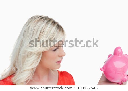 [[stock_photo]]: Woman Seriously Looking At Her Piggy Bank Against A White Background