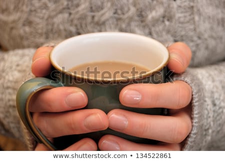 Foto d'archivio: Two Hands Keeping Warm Holding A Hot Cup Of Tea Or Coffee