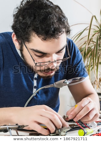 Stock fotó: Concentrating Young Technician Working With His Tablet