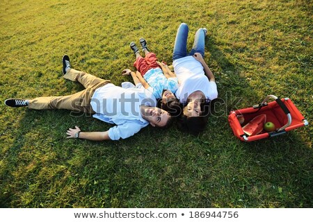 Foto stock: Couple Laying Field With Picnic Basket