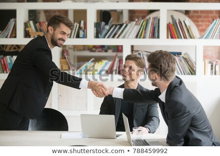 Stock foto: Happy Young Businessman Making A Welcoming Gesture