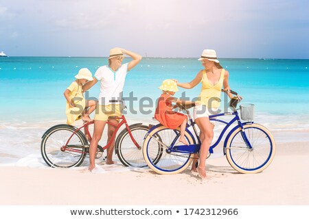 Foto stock: Daughter And Mother On Bicycle In Beach Sea