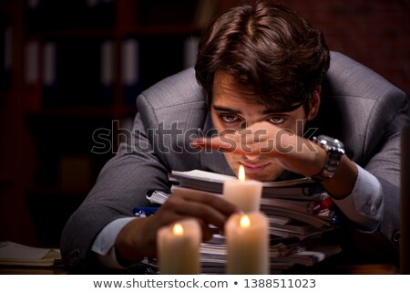 Foto stock: Businessman Working Late In Office With Candle Light
