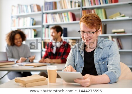 Zdjęcia stock: Smiling Casual Guy Pointing At Curious Stuff On Tablet Display