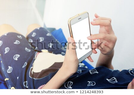 Stockfoto: Beautiful Young Female Using Smartphone In Bedroom