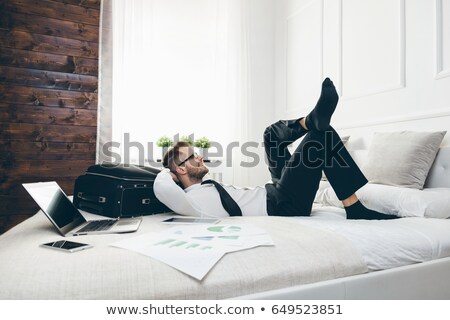 Foto stock: Businessman On Bed Working With A Laptop From His Hotel Room