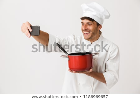 Stockfoto: Young Chef Man Standing Isolated Over White Wall Background Holding Crockery