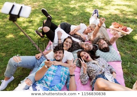 Foto stock: Friends Taking Picture By Selfie Stick At Picnic