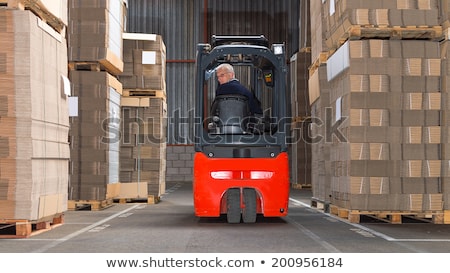 Foto stock: Worker In Logistics Distribution Center With His Forklift