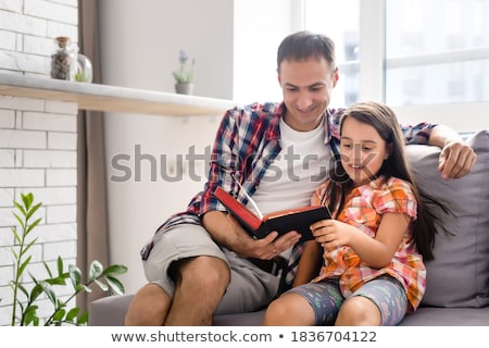 Stok fotoğraf: Young Father With His Little Daughter Reads The Bible